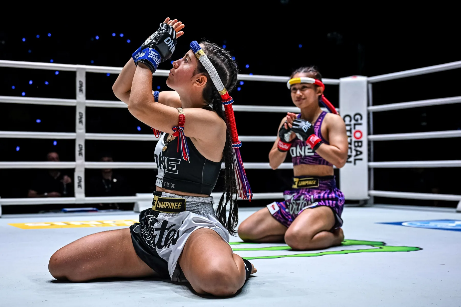 Two fighters kneel in the ring at ONE Lumpinee and perform the Wai Kru before their fight